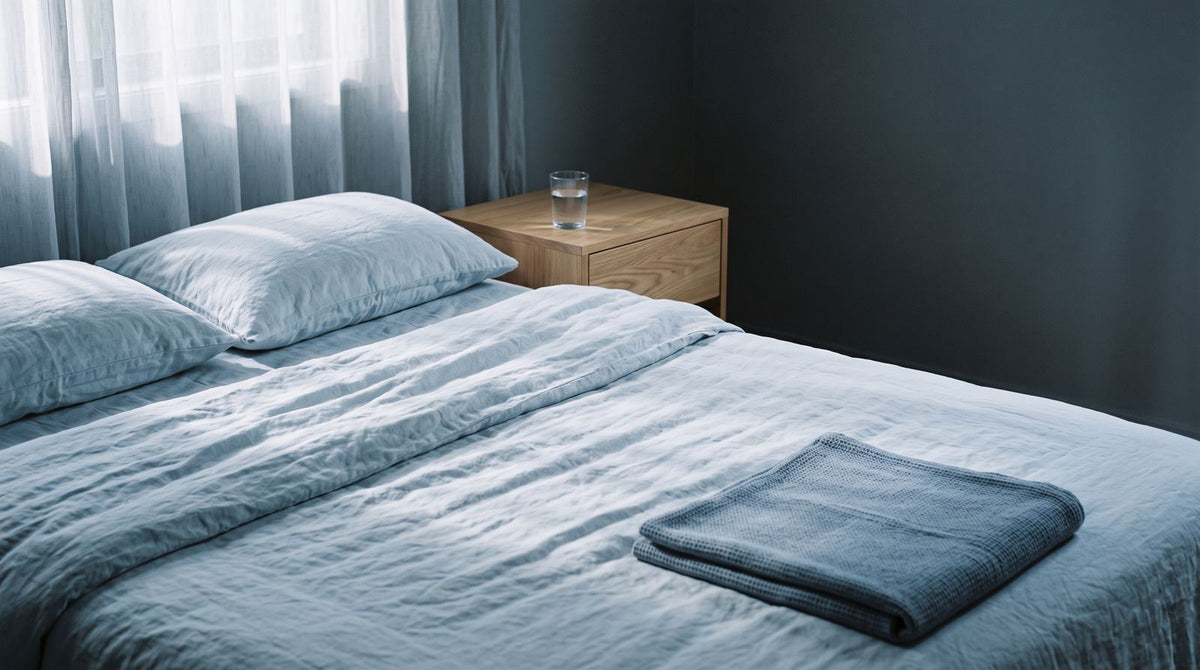 Een opgemaakt bed in zacht licht